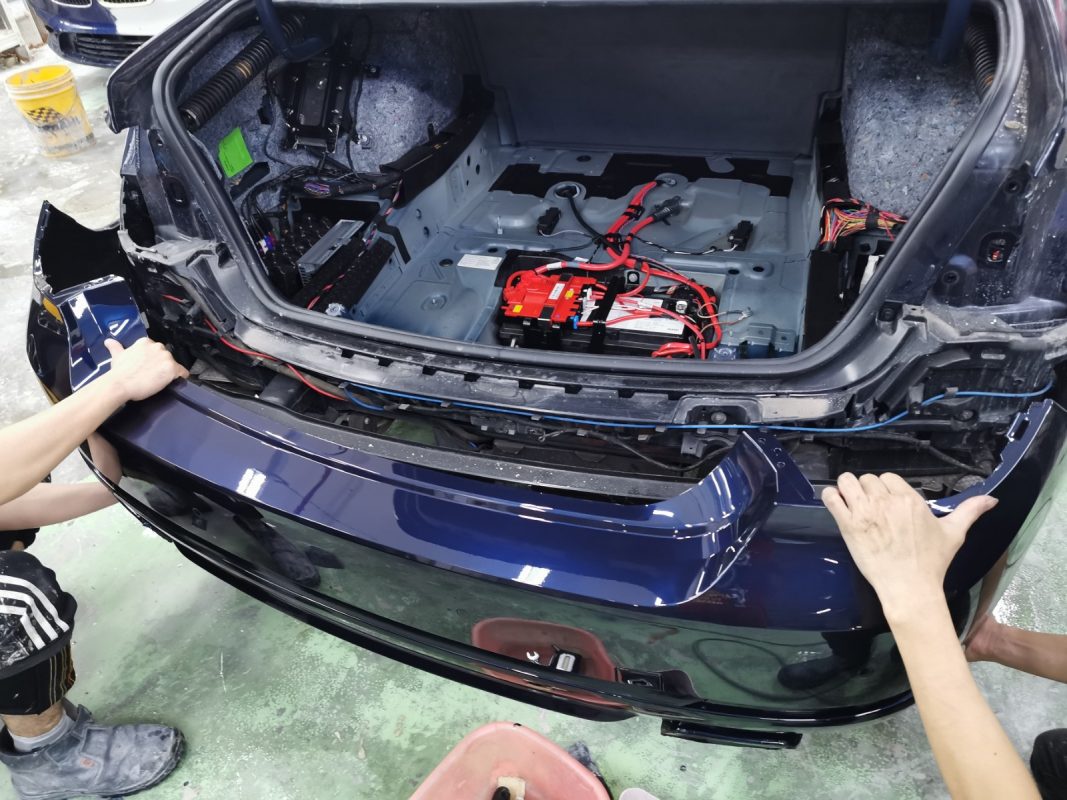 Previously removed car parts being refitted onto the 7 Series.