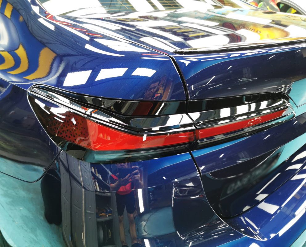 The coated bonnet of the BMW 735i under workshop lighting.