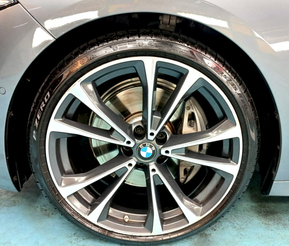 The coated bonnet of the BMW 8 Series under workshop lighting.