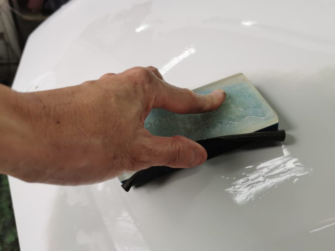 Wet-sanding the BMW 840i Cabriolet's surface to create a smooth, level foundation.