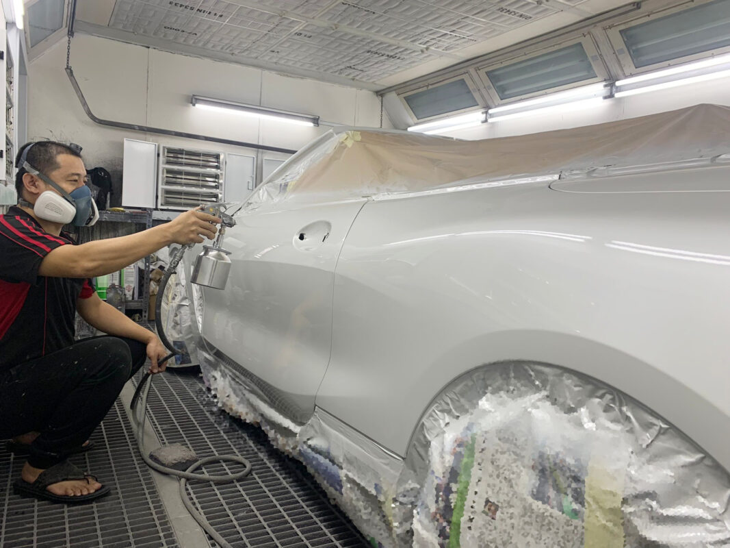 The BMW 840i Cabriolet in the spray booth on Day 6, masked and ready for painting.