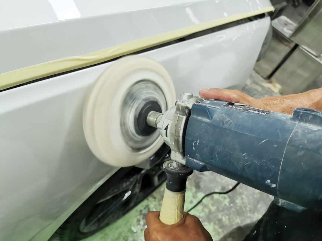 A Revol Carz painter applying the new coat to the BMW 840i Cabriolet in the spray booth.