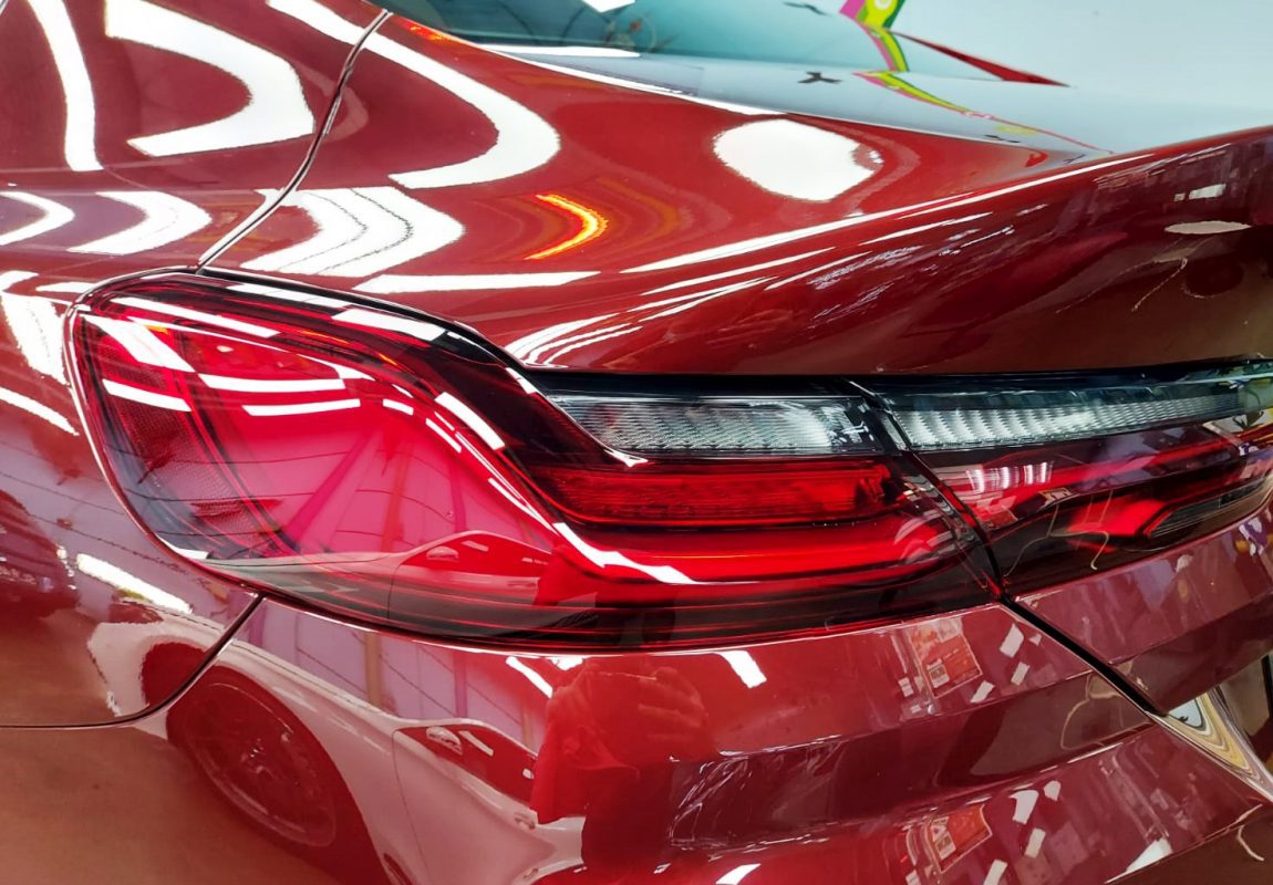 The coated bonnet of the BMW 840i under workshop lighting.