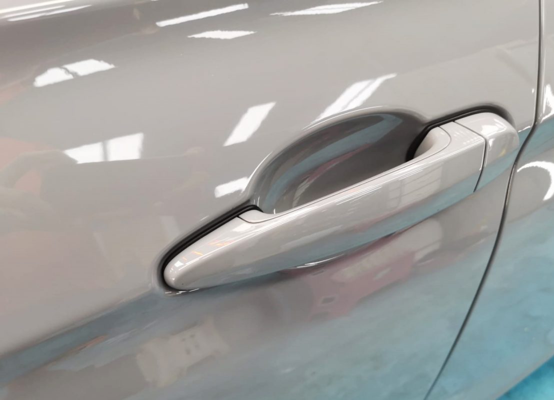 The 330i's coated bonnet under workshop lighting.