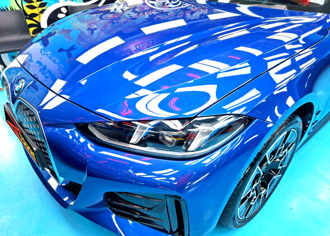 The BMW i4's coated paintwork under workshop lighting.