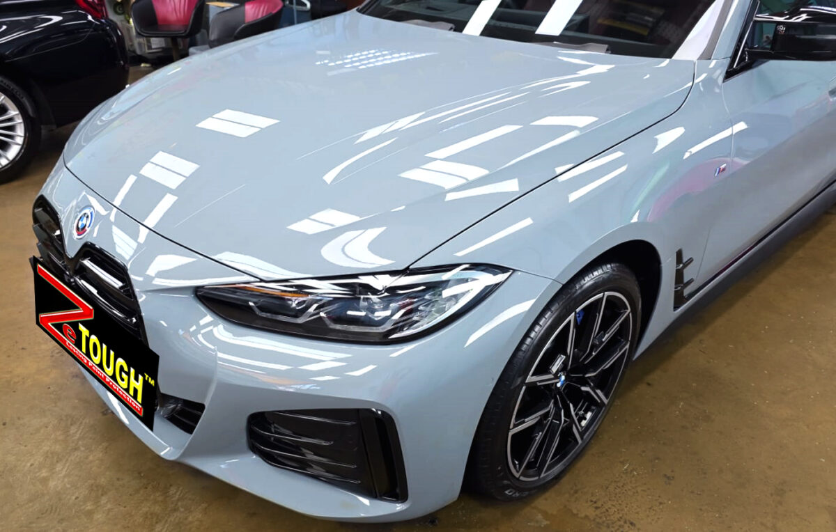 The BMW i4's coated paintwork under workshop lighting.