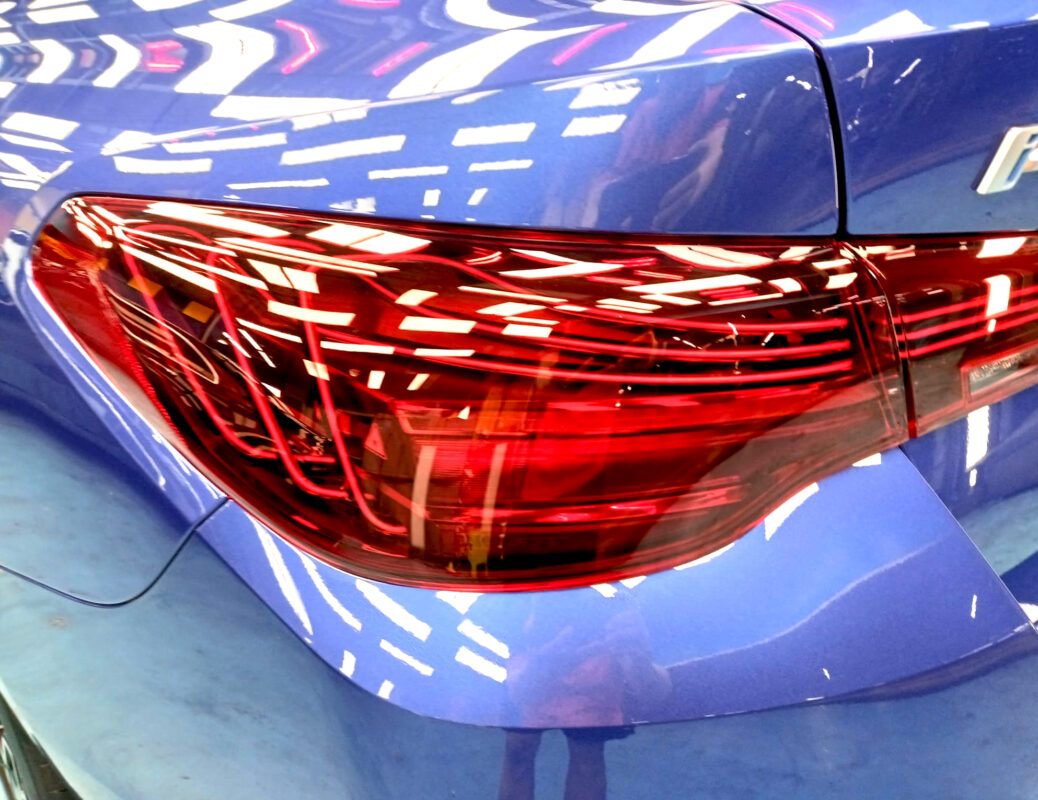 The coated bonnet of the BMW i4 under workshop lighting.