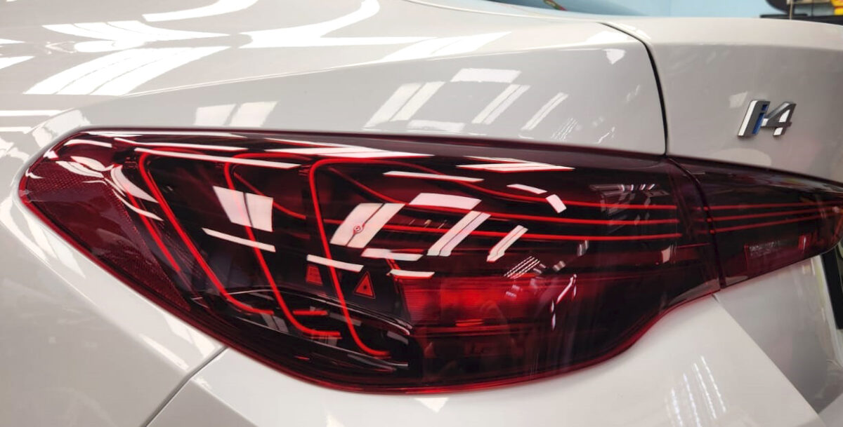 The coated bonnet of the BMW i4 under workshop lighting.