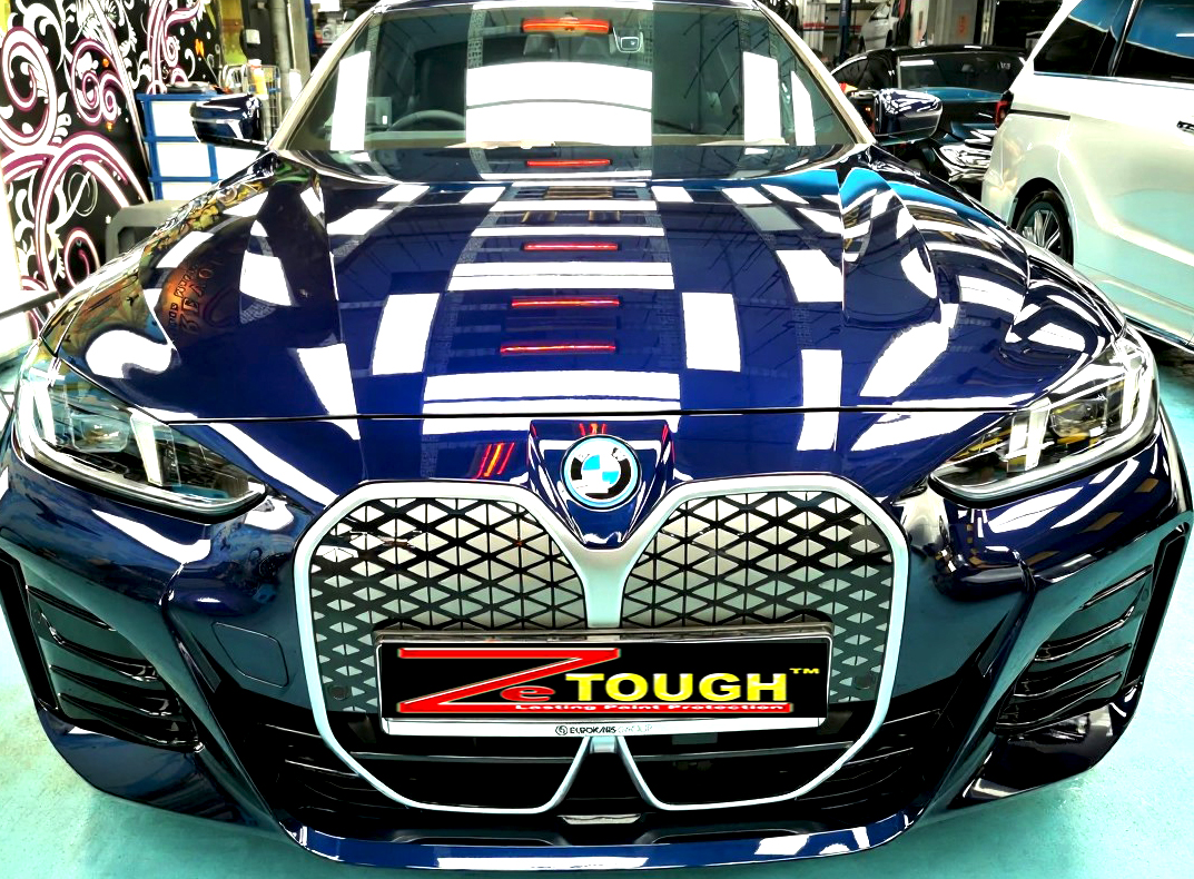 The BMW i4's coated paintwork under workshop lighting.