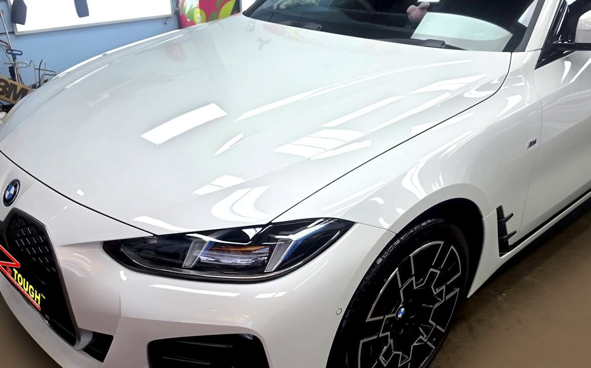 Bonnet, kidney grille and headlight of the white i4 with soft reflections.
