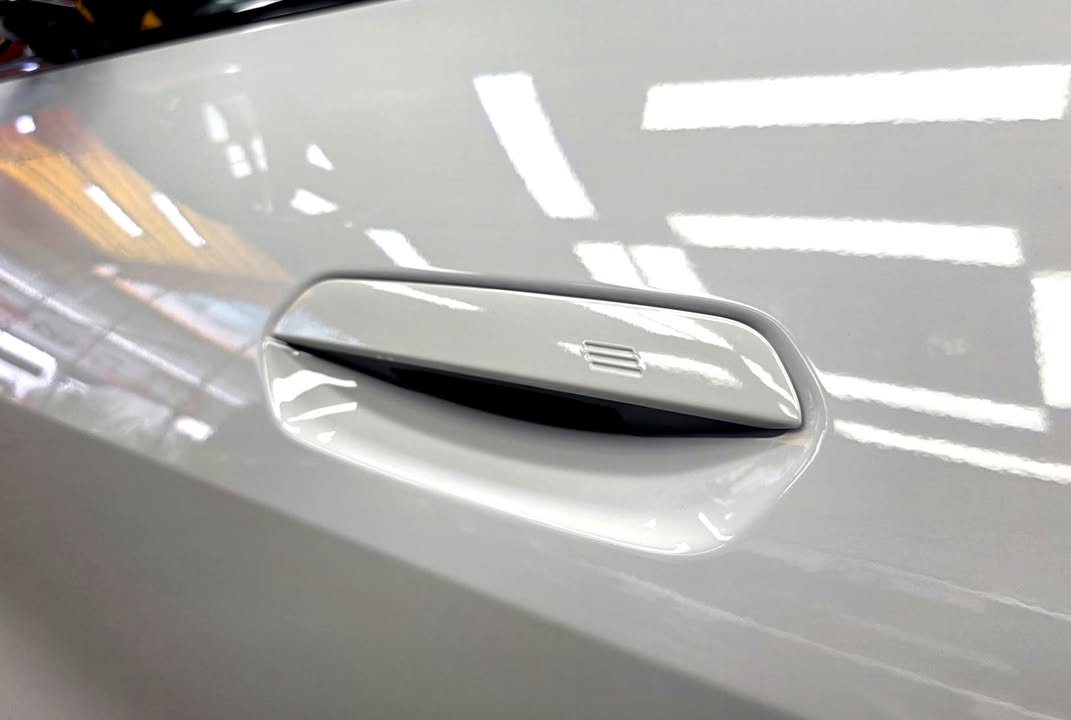 Flush door handle on the white i4 door panel.
