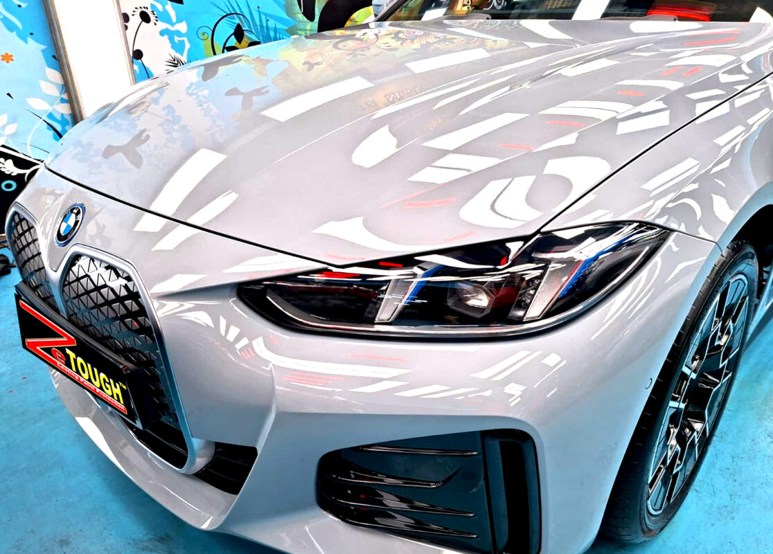 The BMW i4's coated paintwork under workshop lighting.
