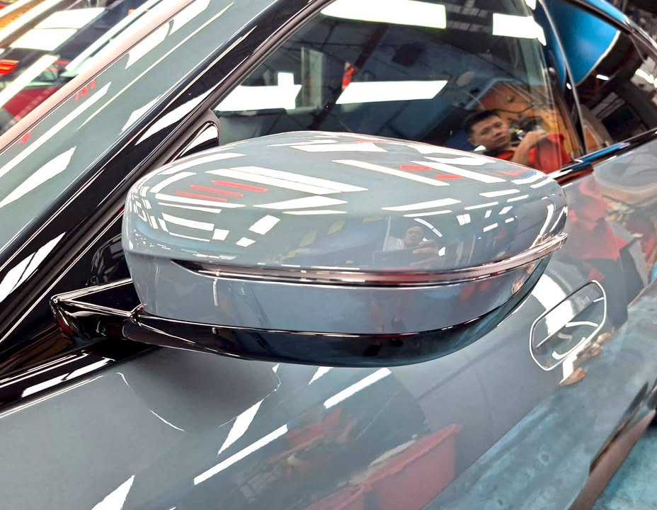 Grey wing mirror on the BMW i4 reflecting the workshop lights.