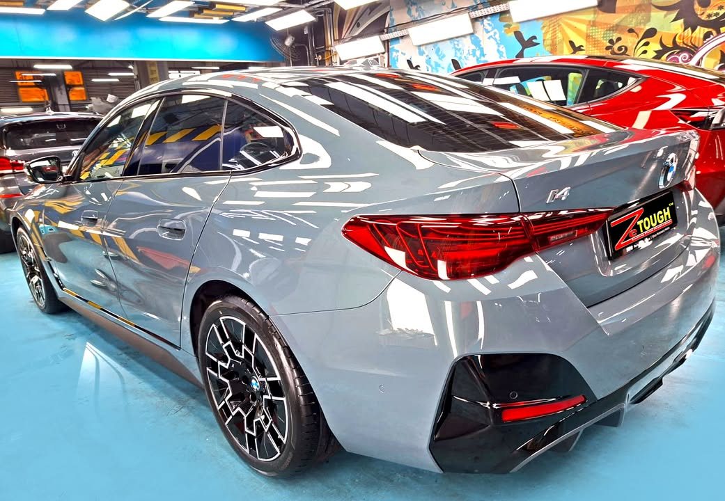 Grey BMW i4, rear three-quarter view, in the workshop.