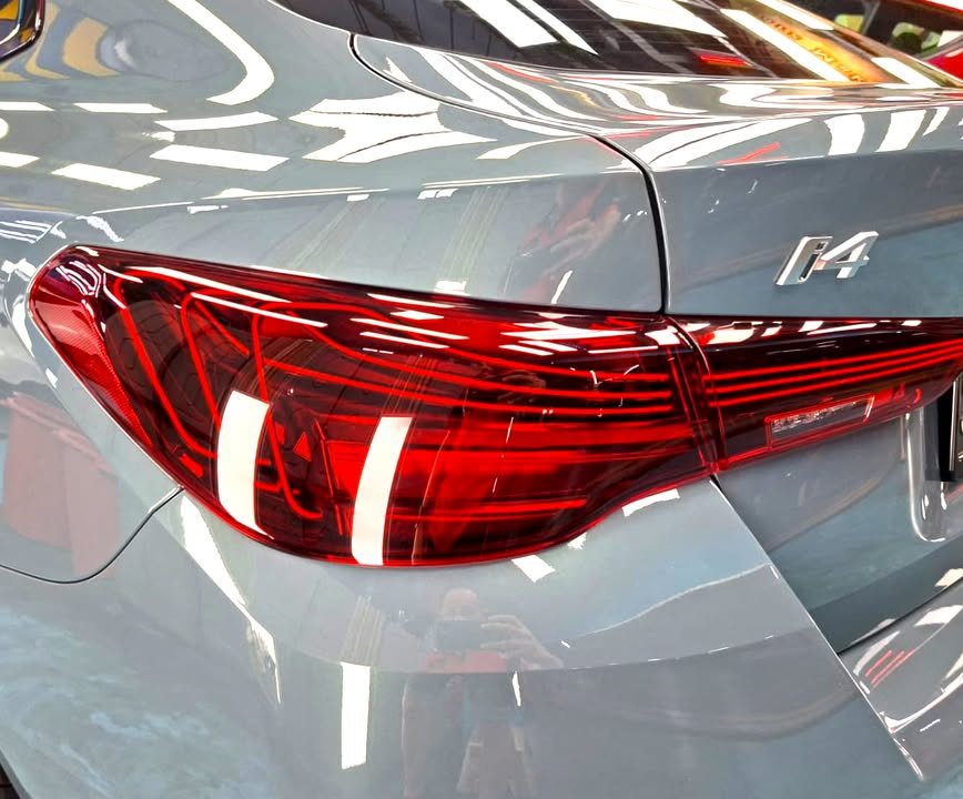 Close-up of the red tail light and i4 badge on the grey bodywork.