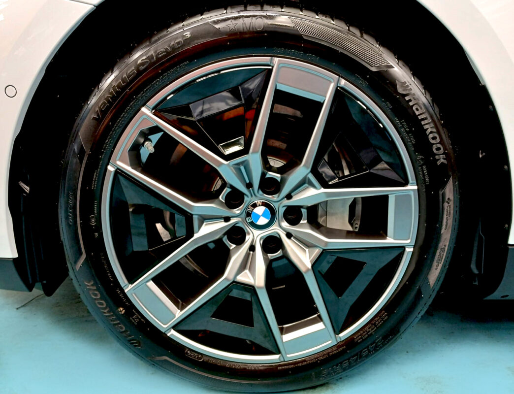 The coated bonnet of the BMW i5 under workshop lighting.