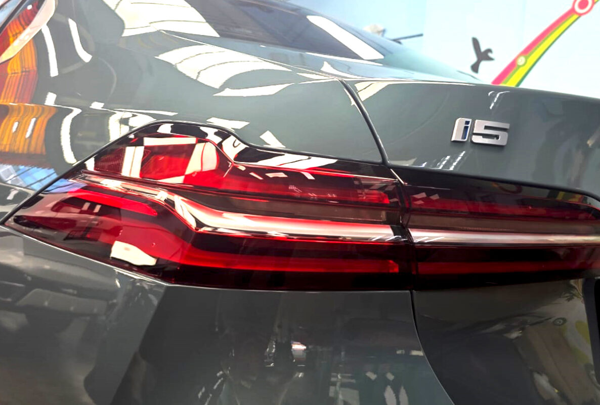 The coated bonnet of the BMW i5 under workshop lighting.