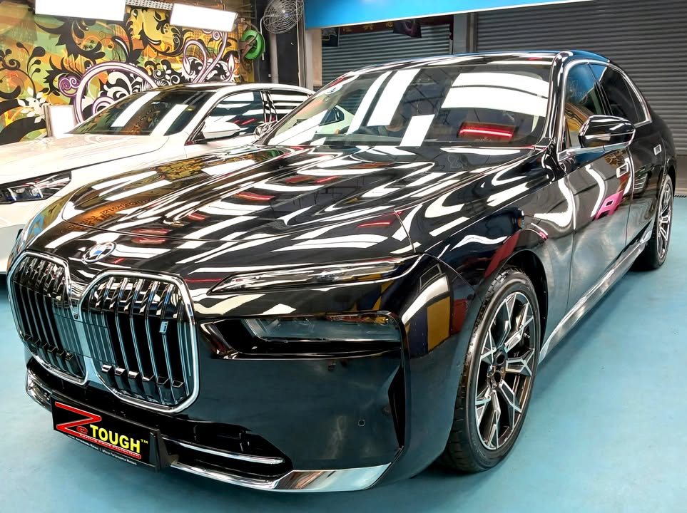 Black BMW i7 front three-quarter view in the Revol Carz workshop after ZeTough Titanium coating.