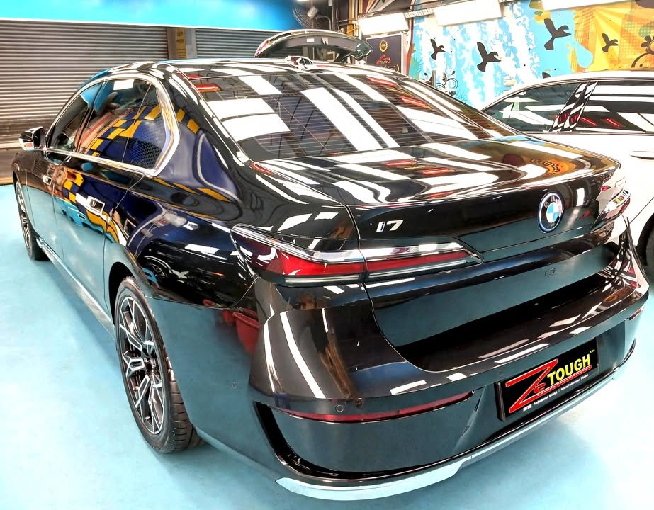 Rear three-quarter view of the black BMW i7 in the workshop.