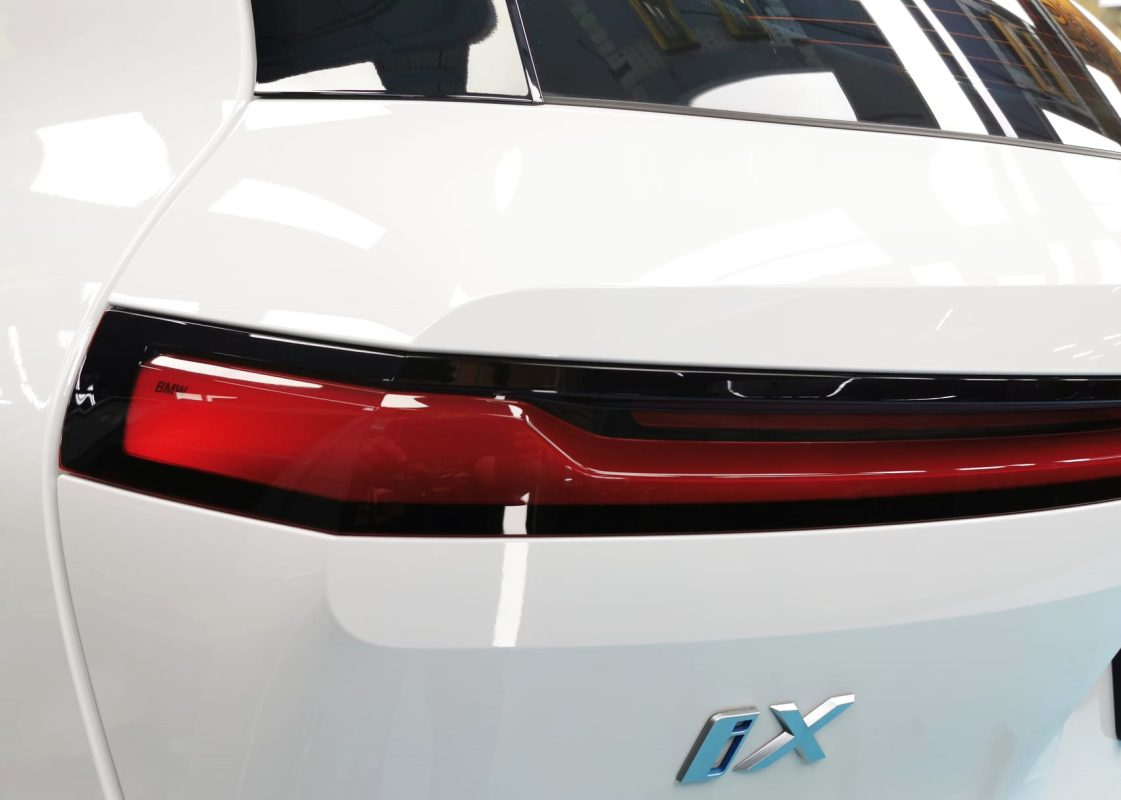The coated bonnet of the BMW iX under workshop lighting.