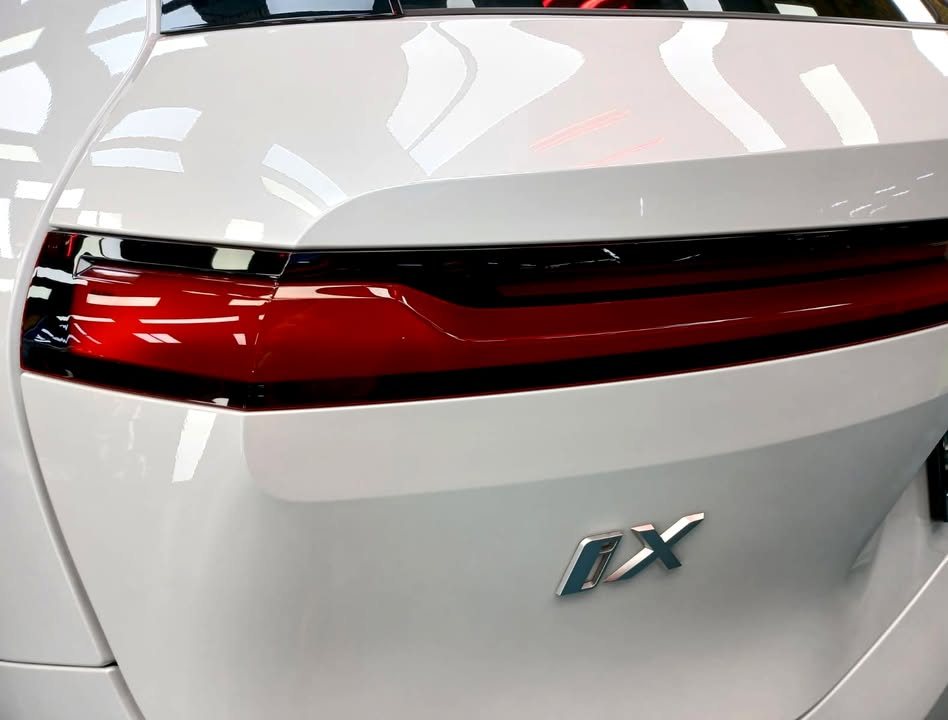Close-up of the red rear light and iX badge on the white tailgate.