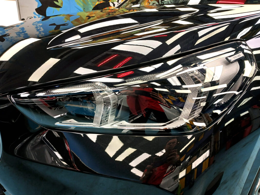 The iX1's coated paintwork showing clean reflections.