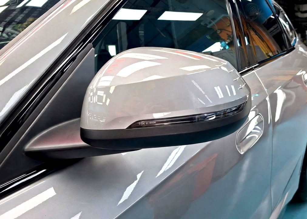 Close-up of the silver door mirror cap on the BMW iX1.