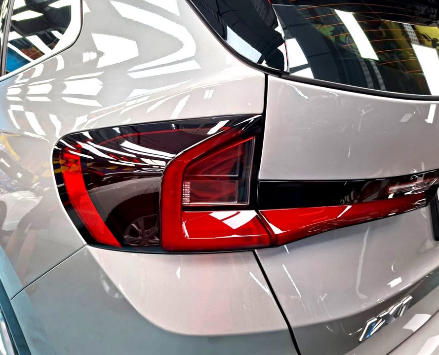 Close-up of the BMW iX1 tail light and silver tailgate.