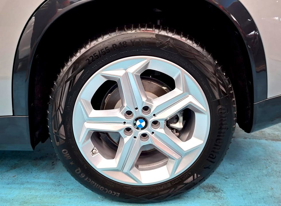 Close-up of the BMW iX1 silver five-spoke alloy wheel and tyre.