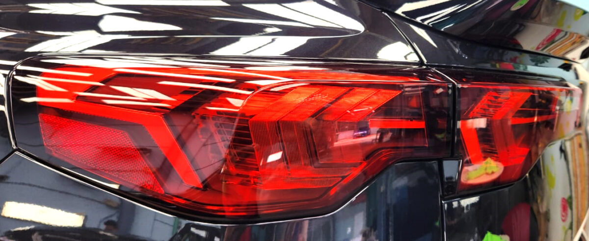 The coated bonnet of the BMW iX2 under workshop lighting.