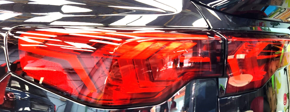 The coated bonnet of the BMW iX2 under workshop lighting.