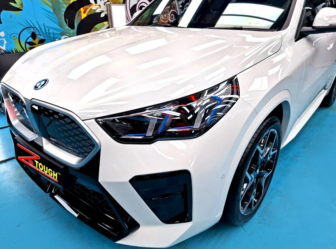The BMW iX2's coated paintwork under workshop lighting.