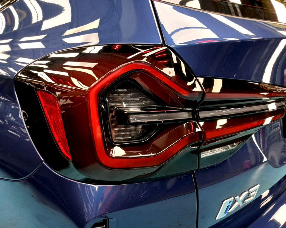The coated bonnet of the BMW iX3 under workshop lighting.