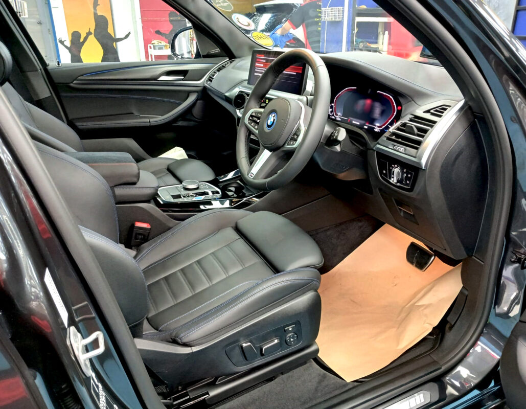 The BMW iX3 parked in the workshop, freshly coated.