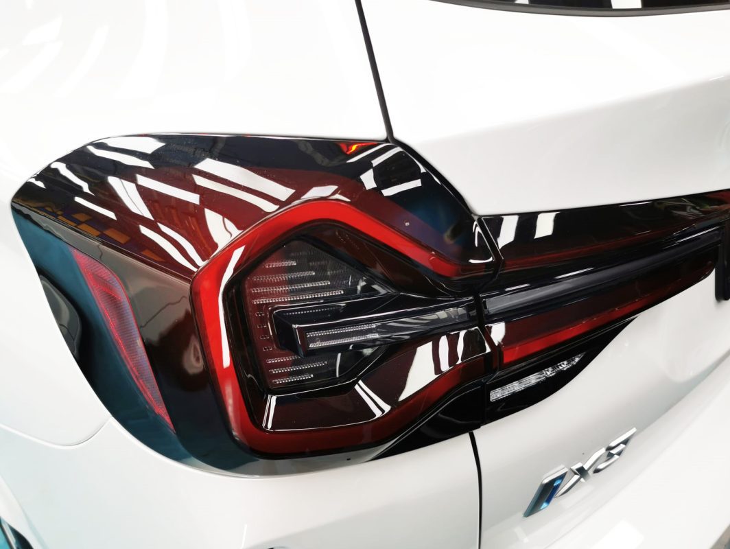 The coated bonnet of the BMW iX3 under workshop lighting.