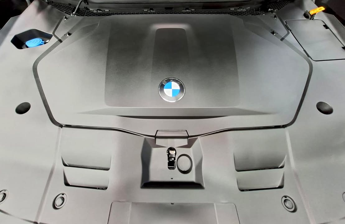 Front storage area under the bonnet with BMW roundel on the cover.