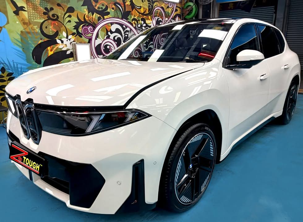 White BMW iX3 front three-quarter view in the Revol Carz workshop after ZeTough Titanium coating.