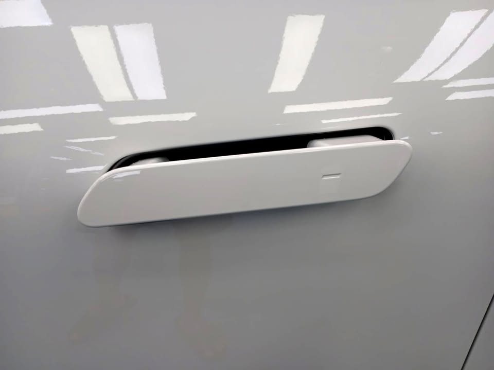 Flush door handle on the white iX3 door panel.