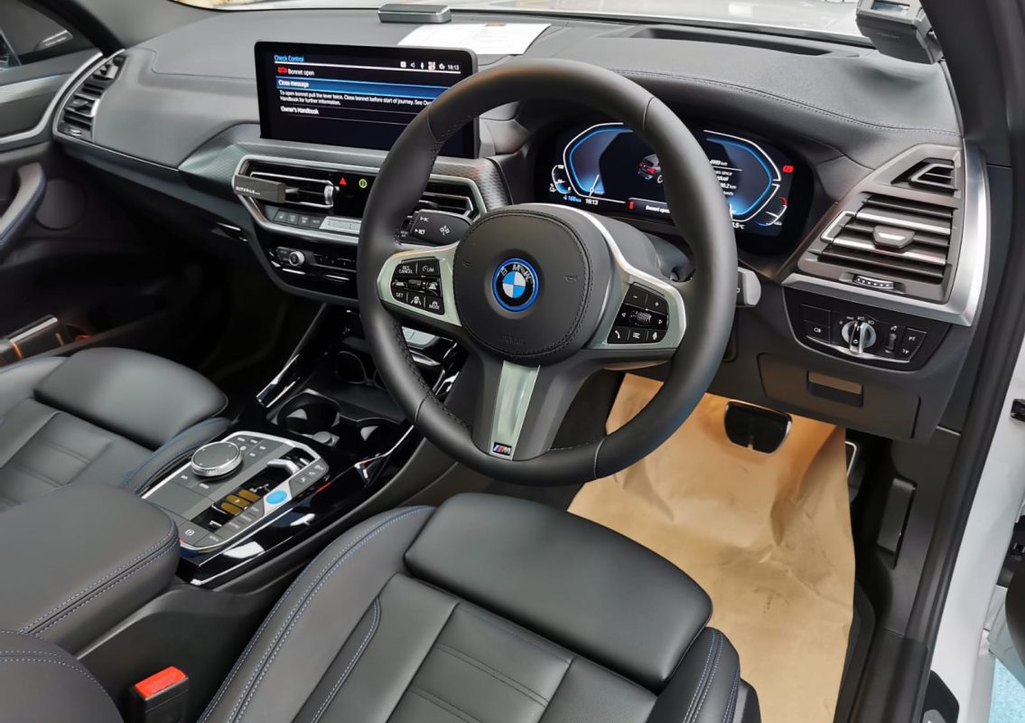 The BMW iX3 parked in the workshop, freshly coated.