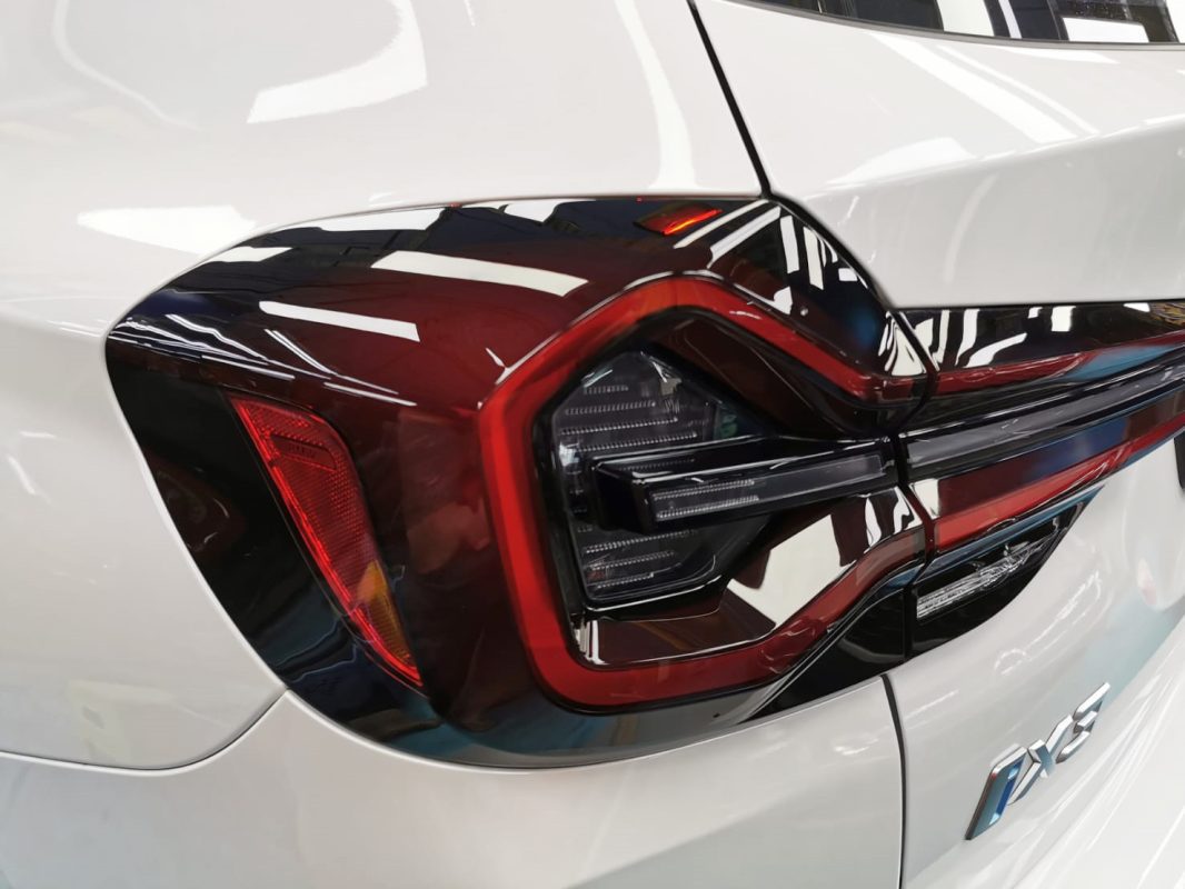 The coated bonnet of the BMW iX3 under workshop lighting.
