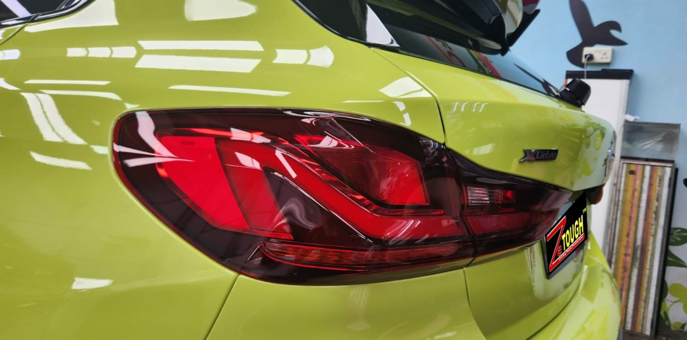 The coated bonnet of the BMW M135i under workshop lighting.