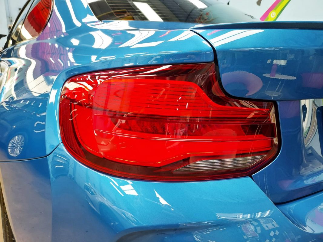 The coated bonnet of the BMW M2 under workshop lighting.