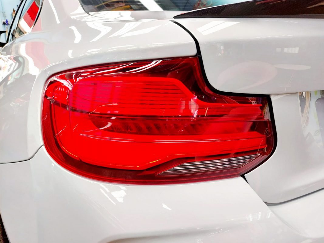 The coated bonnet of the BMW M2 under workshop lighting.