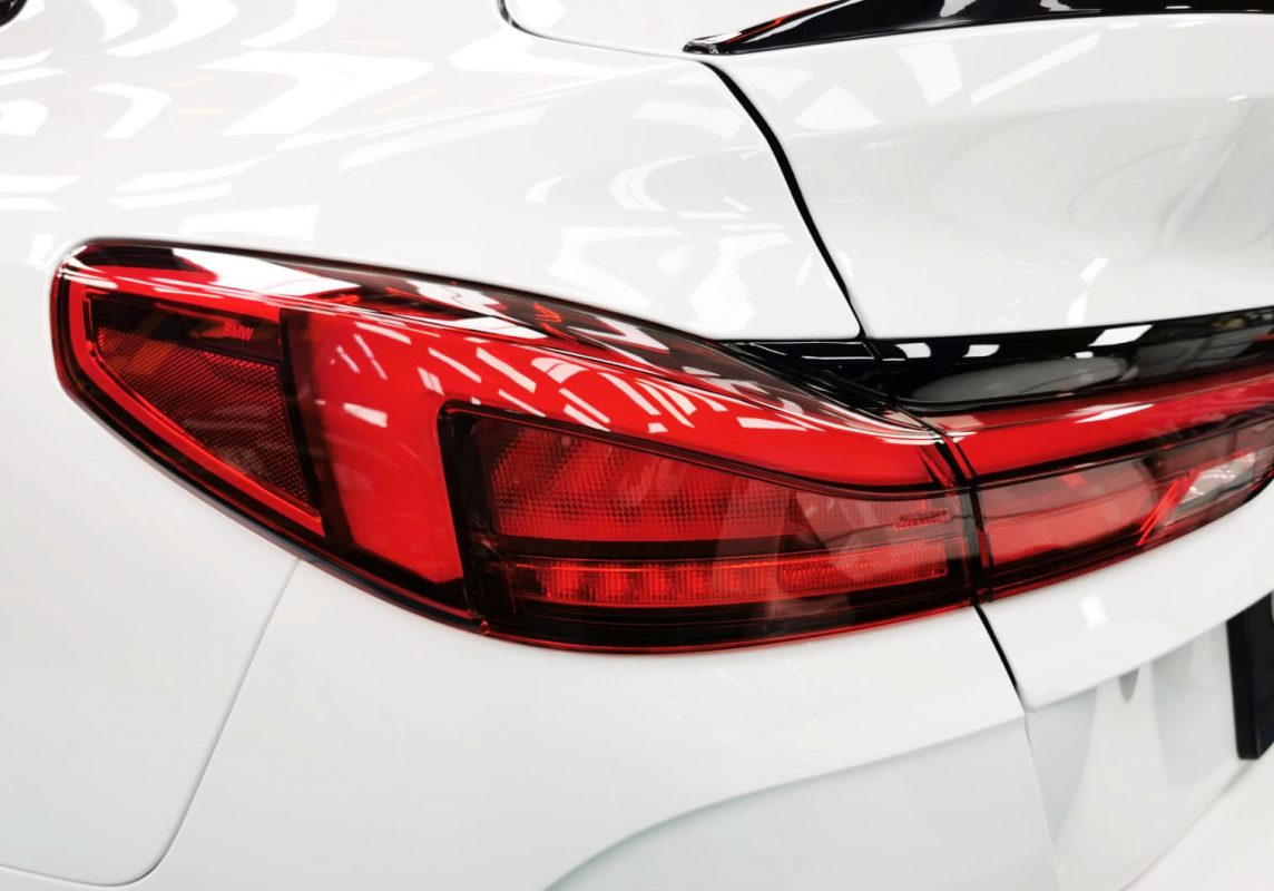 The coated bonnet of the BMW M235i under workshop lighting.