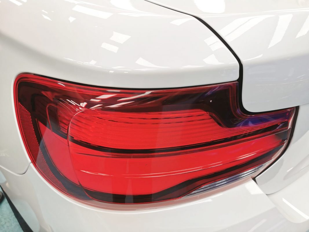 The coated bonnet of the BMW M240i under workshop lighting.