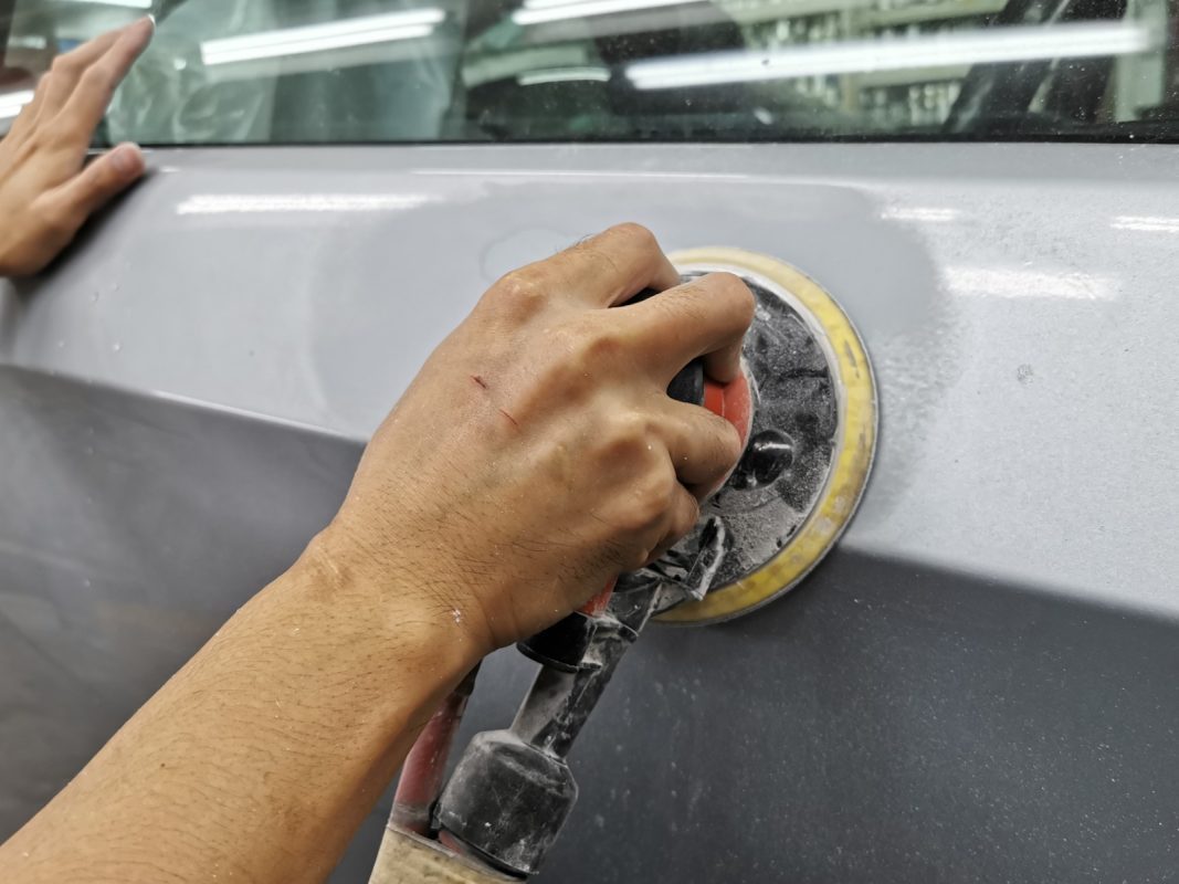 The M3's body being checked and patched for paintwork imperfections.