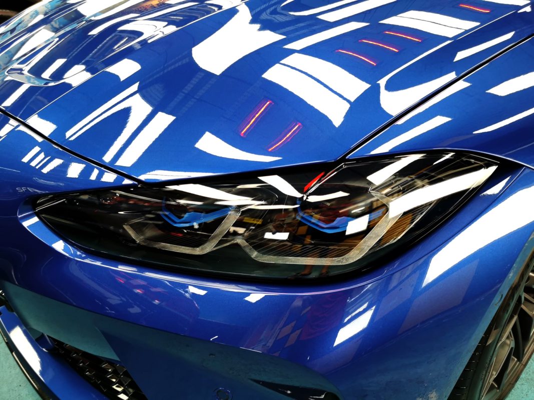 The M3's coated paintwork showing clean reflections.