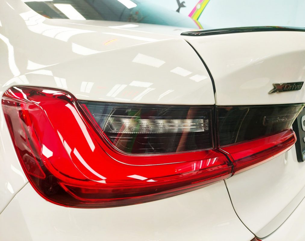 The coated bonnet of the M340i under workshop lighting.