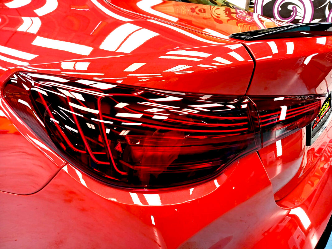 The coated bonnet of the BMW M4 under workshop lighting.