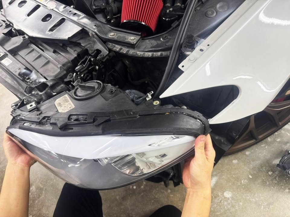 Headlamp being lifted out of the M5's front end.